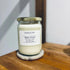 Alpine Forest soy candle in glass jar with gold lid, featuring lemon peel, fir needle, clove, blackcurrant, musk & rose petals scents
